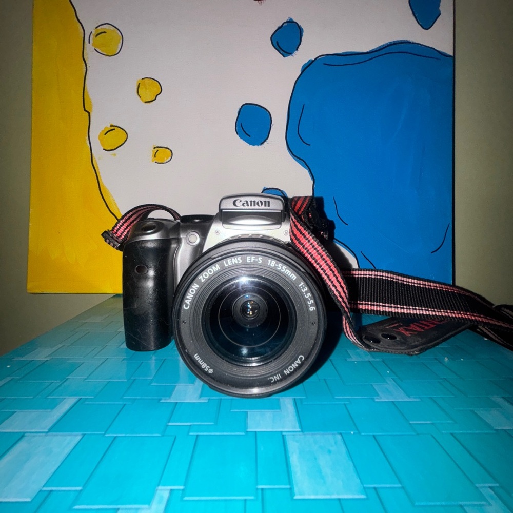 Canon Digital Camera within Black Body and Red Strap doesn’t come with battery